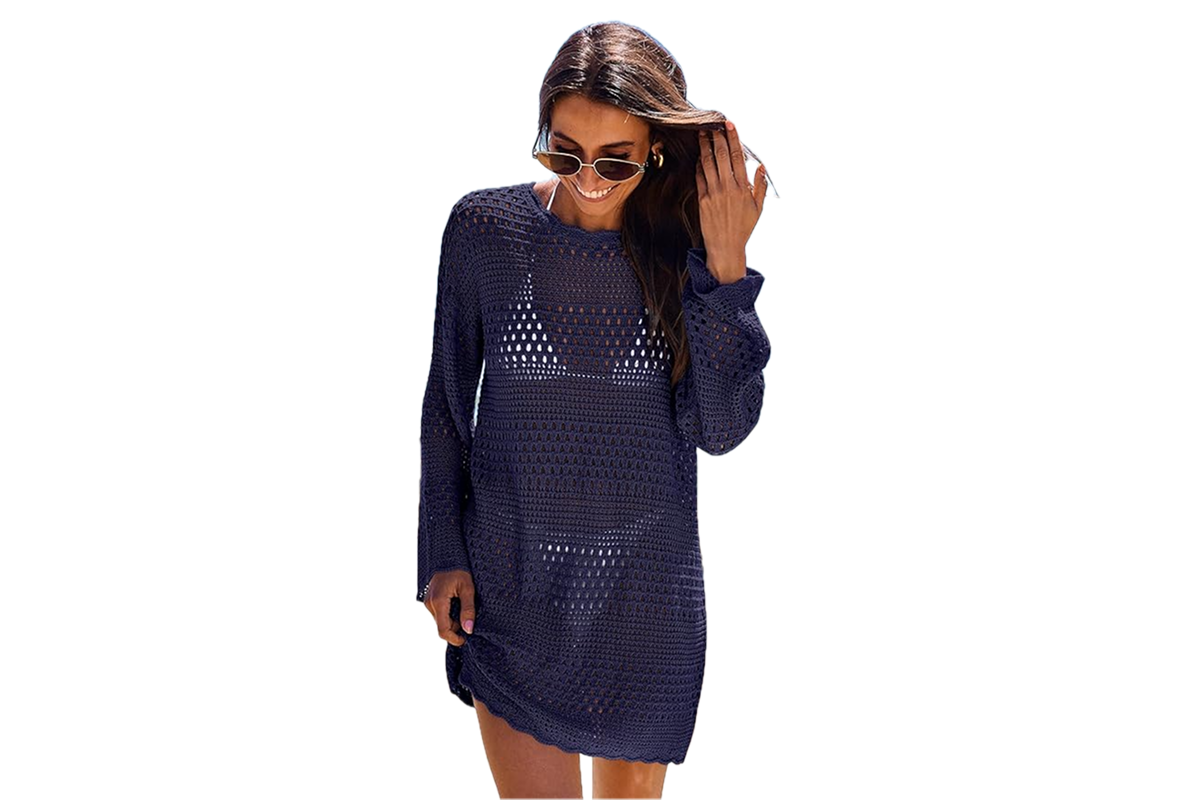 A woman wearing sunglasses and a navy blue, crochet style, beach cover-up.