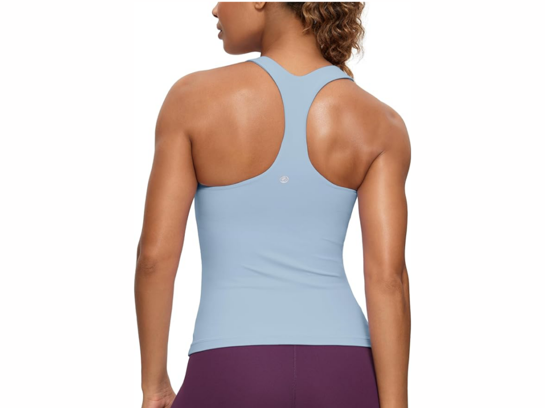 This image features a woman's back. She is wearing a light blue, sleeveless tank top with a T shape back.