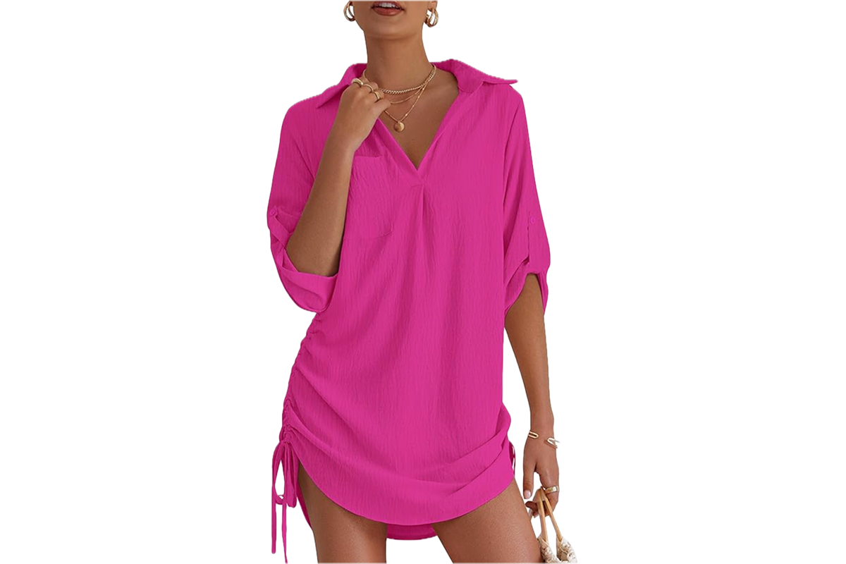 A woman wearing a bright pink shirt dress with drawstring sides.