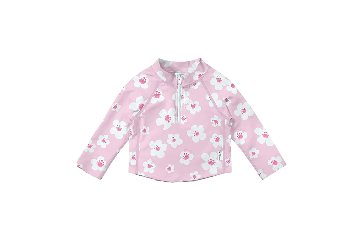 A long sleeve top with a zipper at the neck and a solid pink background with pink and white flowers.