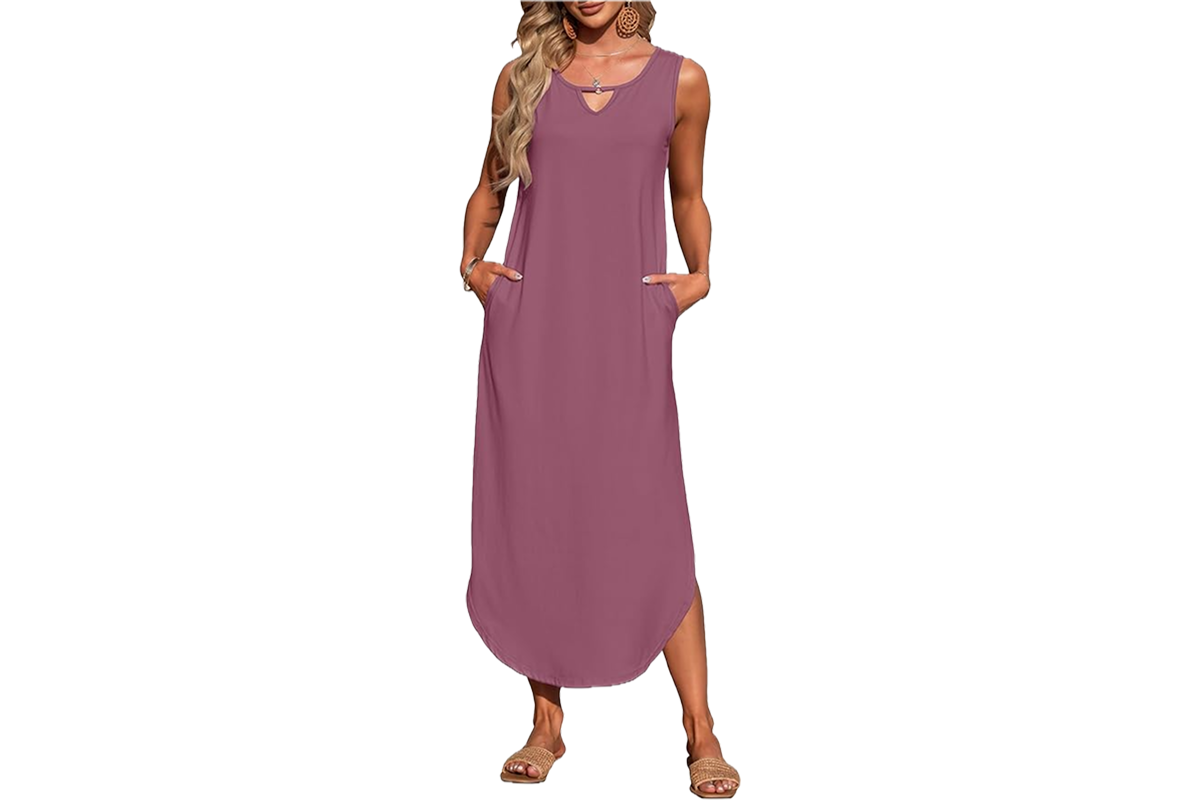 A woman wearing a mauve color, mid length, sleeveless dress with a cut out feature at her neck.