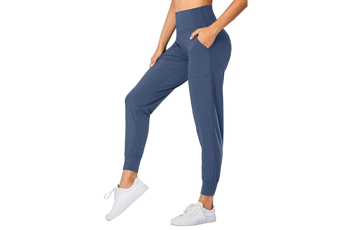 This image features the lower half of a woman's body wearing a pair of jogger style yoga pants in blue.