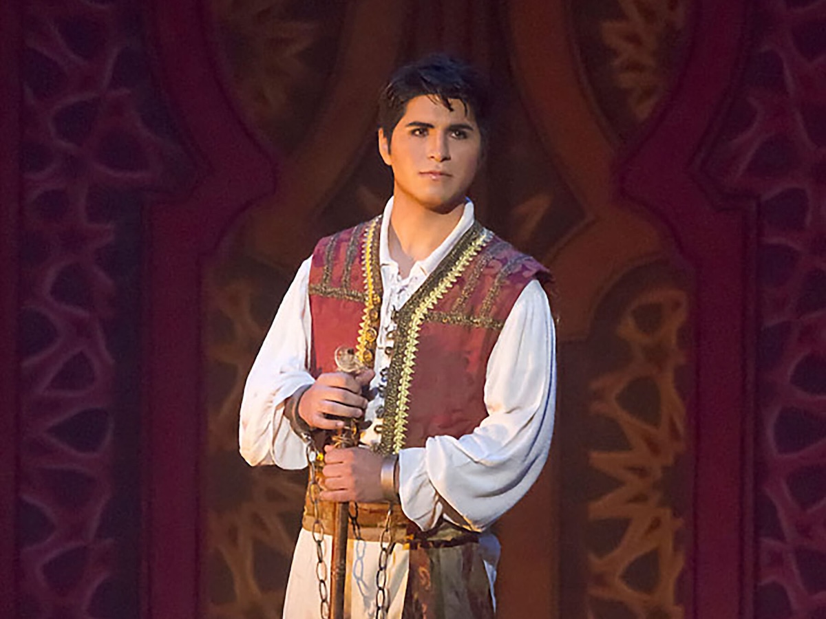 Actor standing on stage in 1800s period Spanish dress