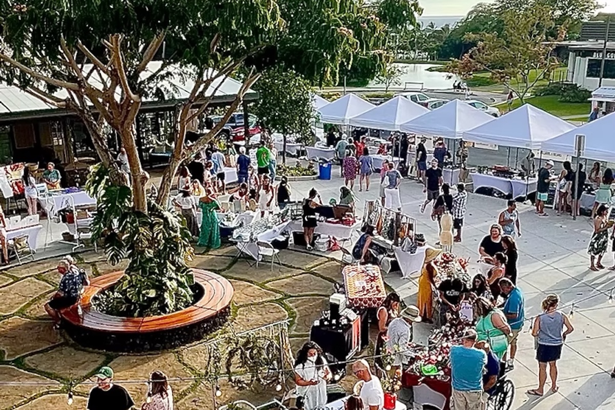 An overhead shot of a farmers market, with lots of people milling about.