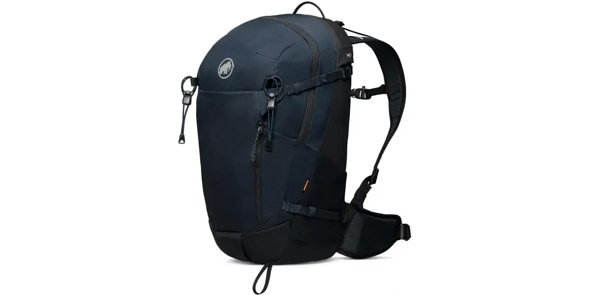A sleek, dark navy blue sustainably-made backpack with a zippered main compartment, side compression straps, and a top handle. It has an adjustable shoulder strap and a padded waist belt for support. The bag features a small logo on the front and zipper pulls with loops for easy access.