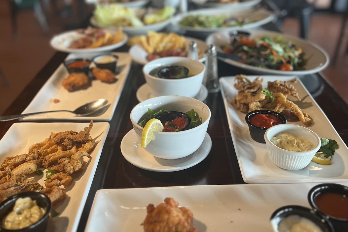 Plates of food with fried chicken, fries, salad and more.
