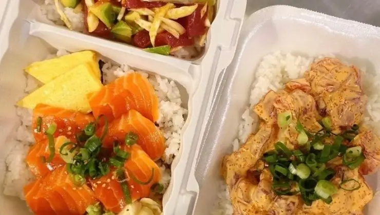 Three takeout containers with the best poke Waikiki Oahu has to offer. One features salmon sashimi on rice with green onions and sesame seeds. Another has spicy salmon on rice with green onions. The third includes diced tuna, cucumber, and avocado salad on rice, topped with slices of egg omelet.