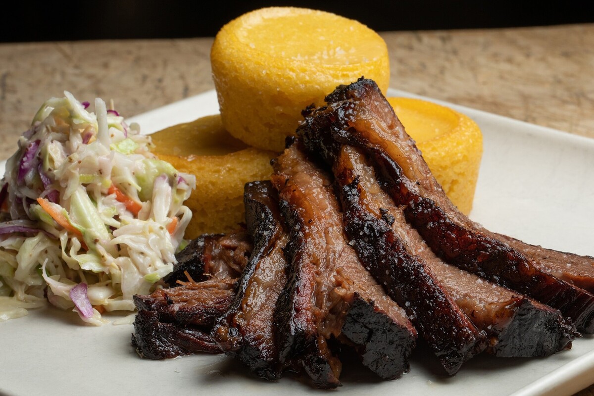 Pieces of roasted meat with coleslaw and cornbread tarts.