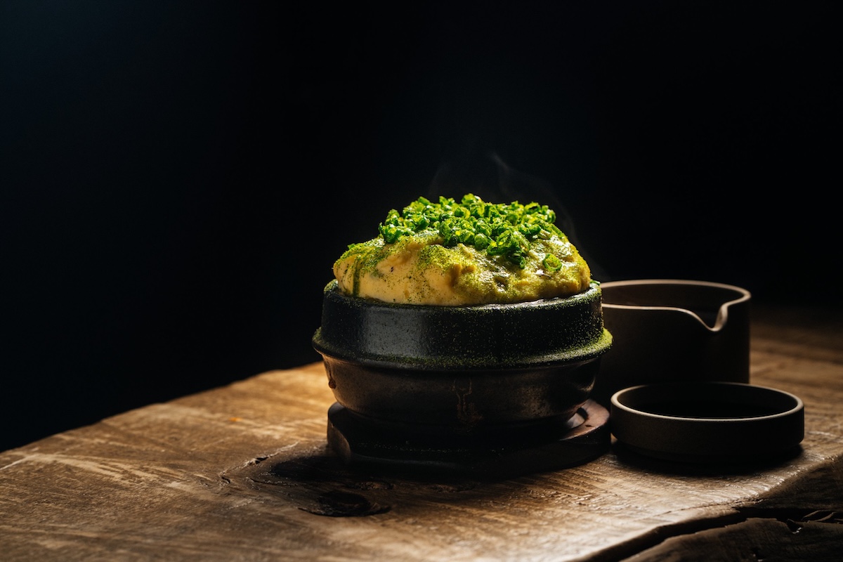A savory egg souffle topped with green dust and green onion.