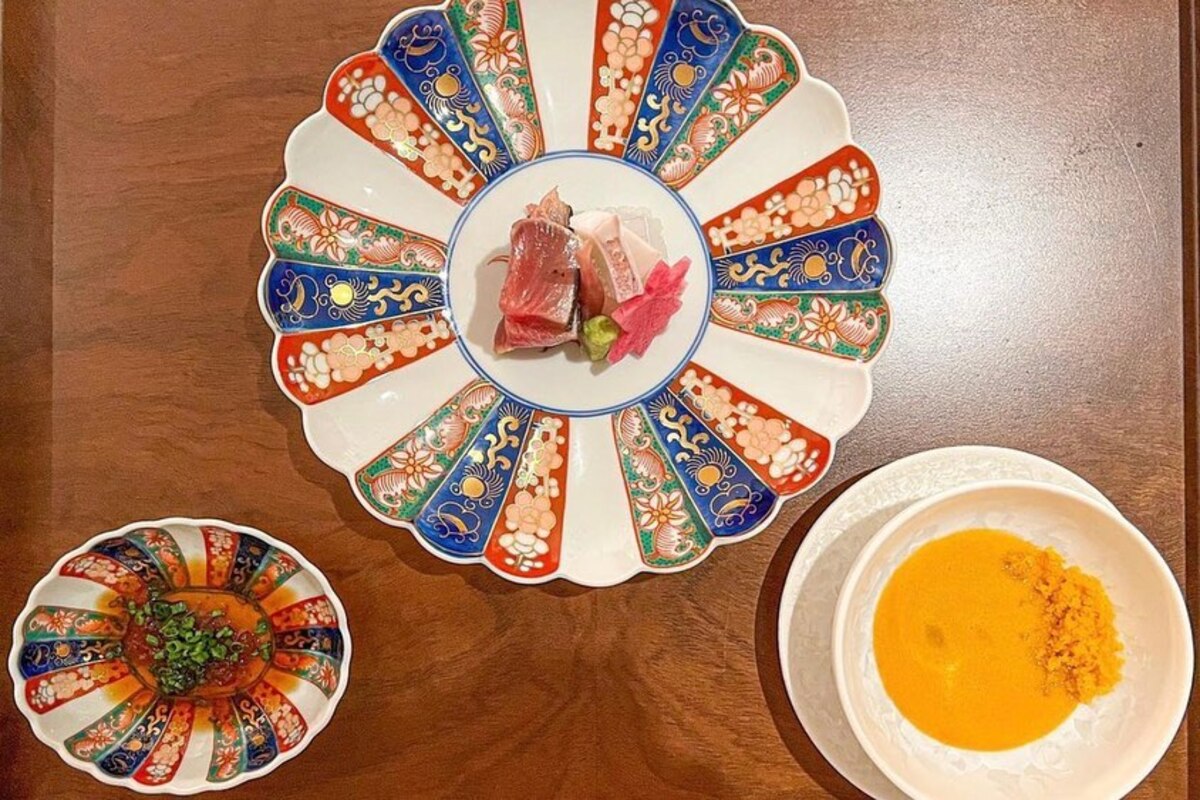 Colorful scalloped plates with sauce and slices of fish.
